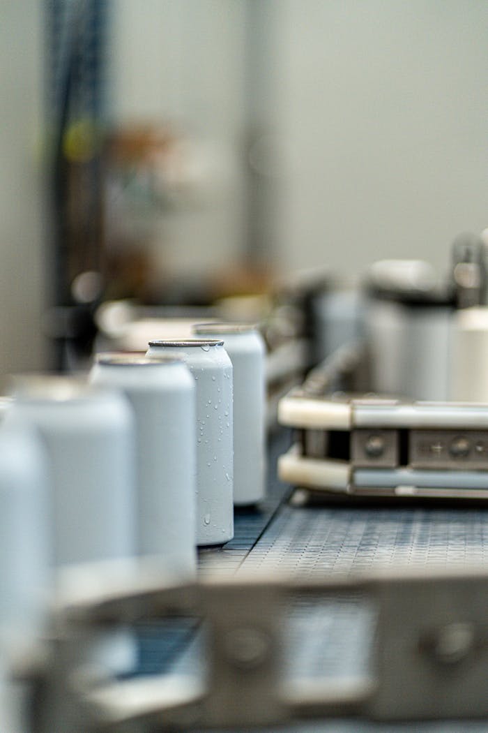 about-us-02 Focus on beer cans mid-production on a canning line with blurred background.